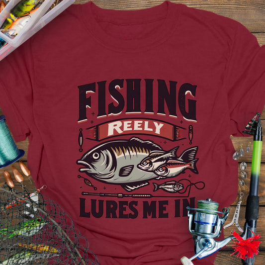 Cardinal Red Unisex T-shirt featuring the phrase 'Fishing Reely Lures Me In' with a detailed graphic of a fish and fishing lures. Perfect for anglers and fishing enthusiasts, this comfortable tee is great for casual wear, fishing trips, and outdoor adventures.