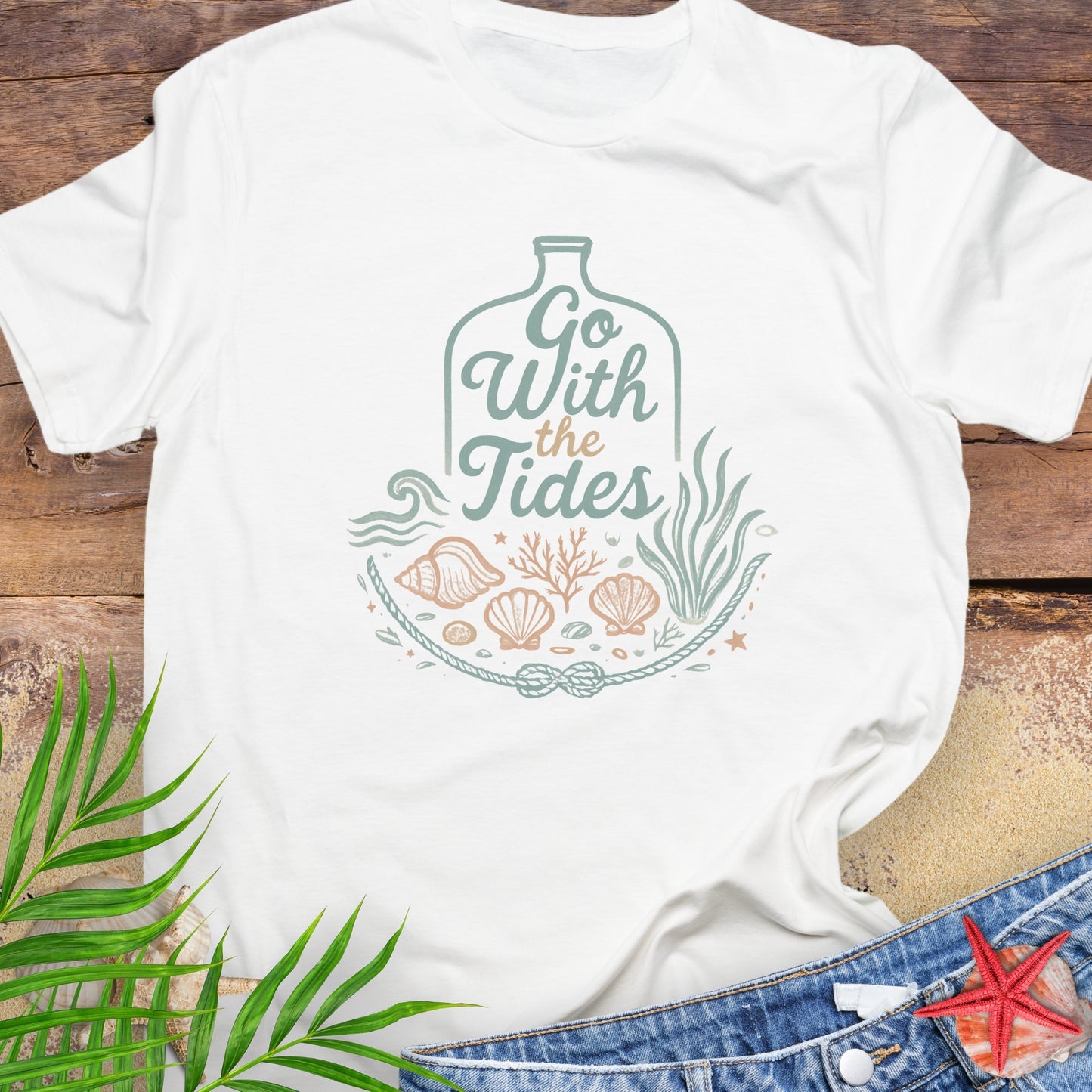 White Go With the Tides t-shirt with ocean bottle design, seashells, and coral artwork.