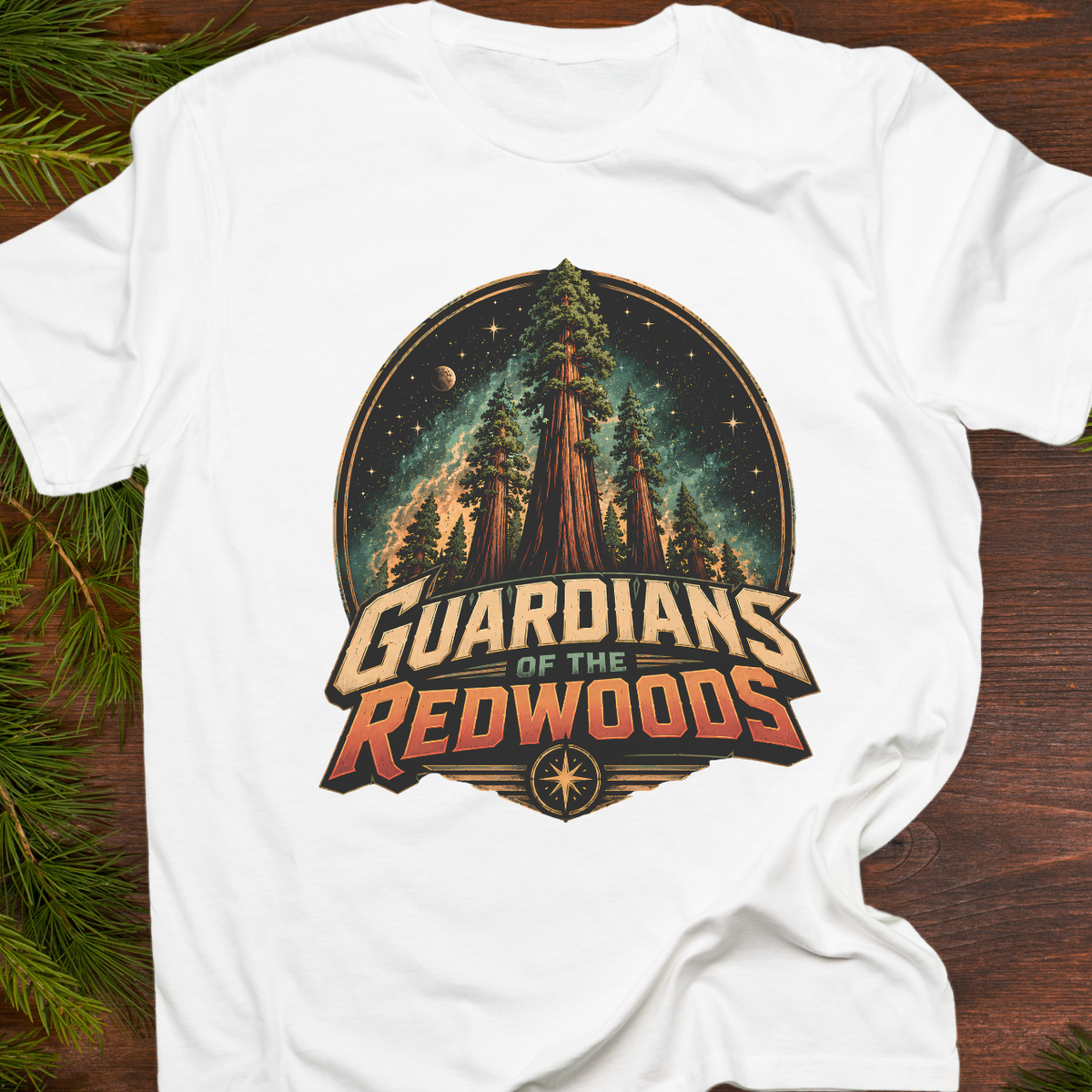 White t-shirt with 'Guardians of the Redwoods' graphic design on a wooden surface with greenery.