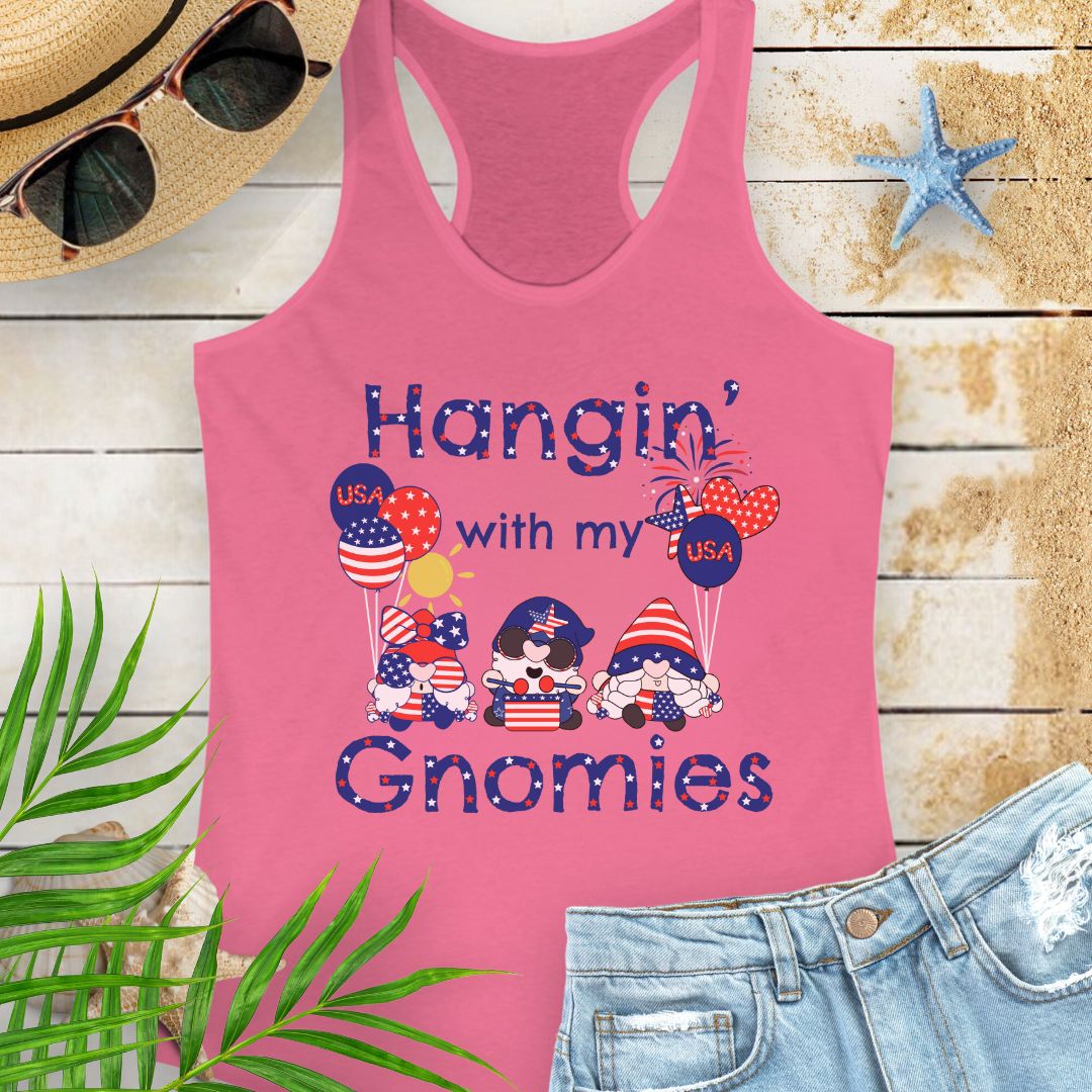 Pink women’s racerback tank top with patriotic gnomes holding American flag balloons, with fireworks and sunshine in the background.