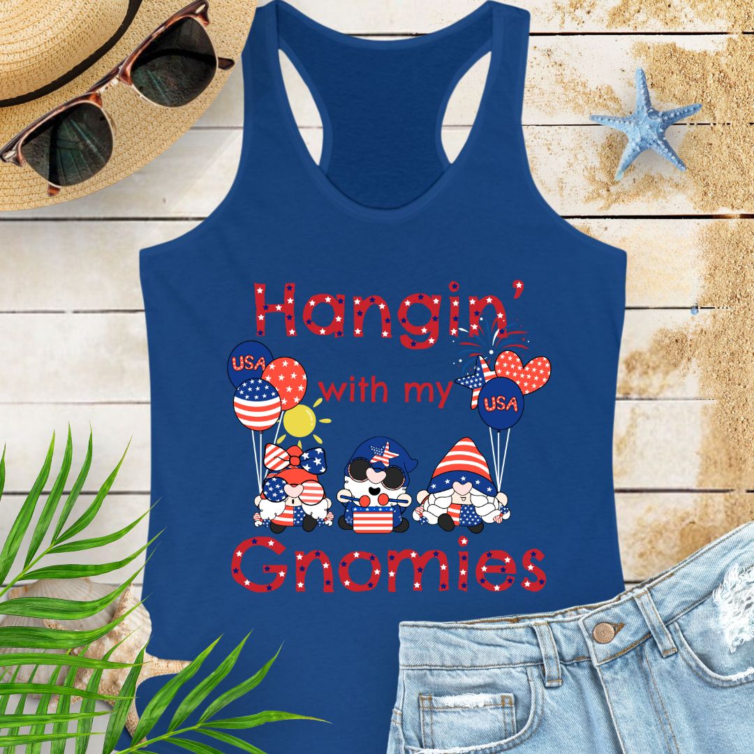 Royal blue women’s racerback tank top with patriotic gnomes holding American flag balloons, with fireworks and sunshine in the background.