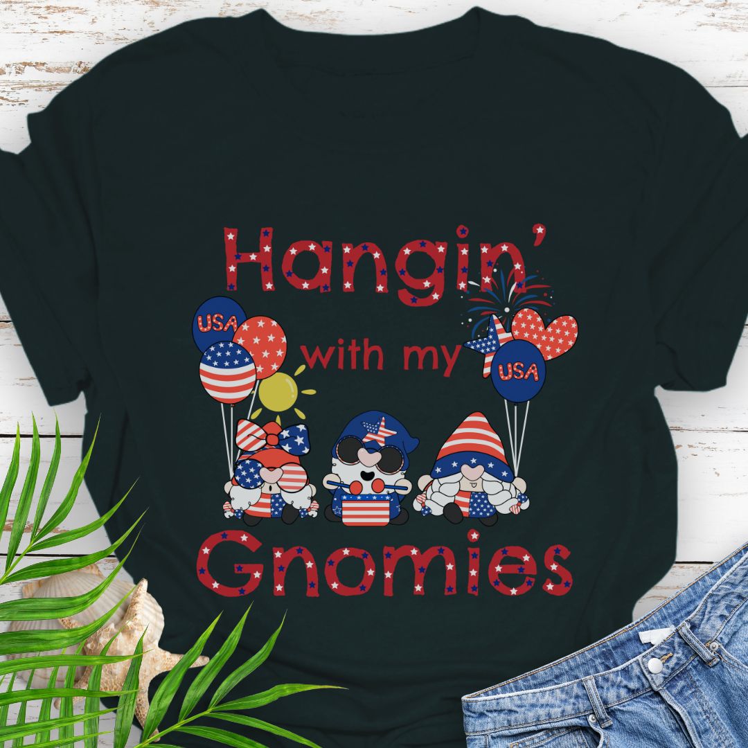 Black T-shirt with three gnomes in patriotic outfits holding flag balloons with sun and fireworks in the background with the phrase Hangin' with my Gnomies.