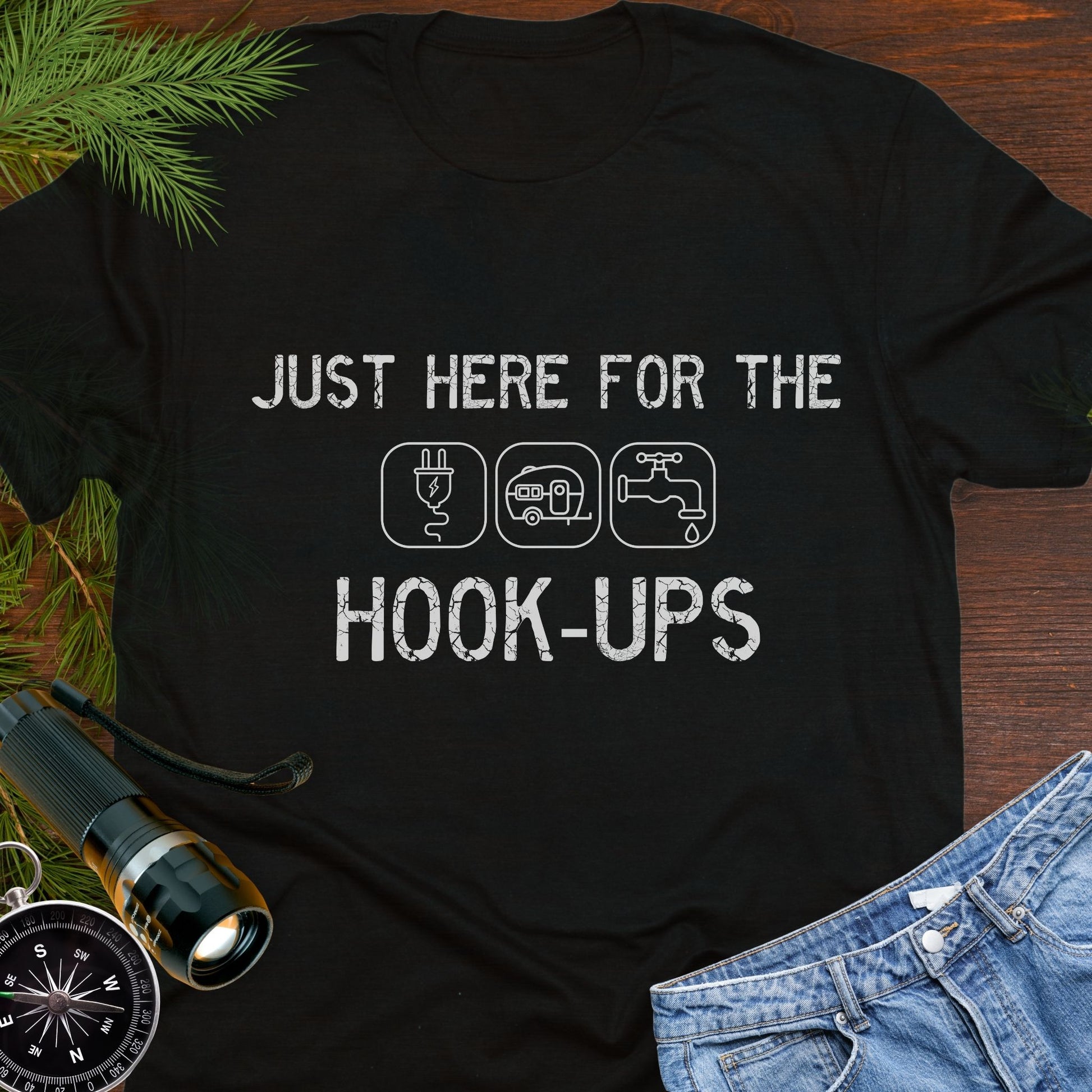 Black funny camping t-shirt with ‘Here for the Hook-ups’ text and RV utility icons.