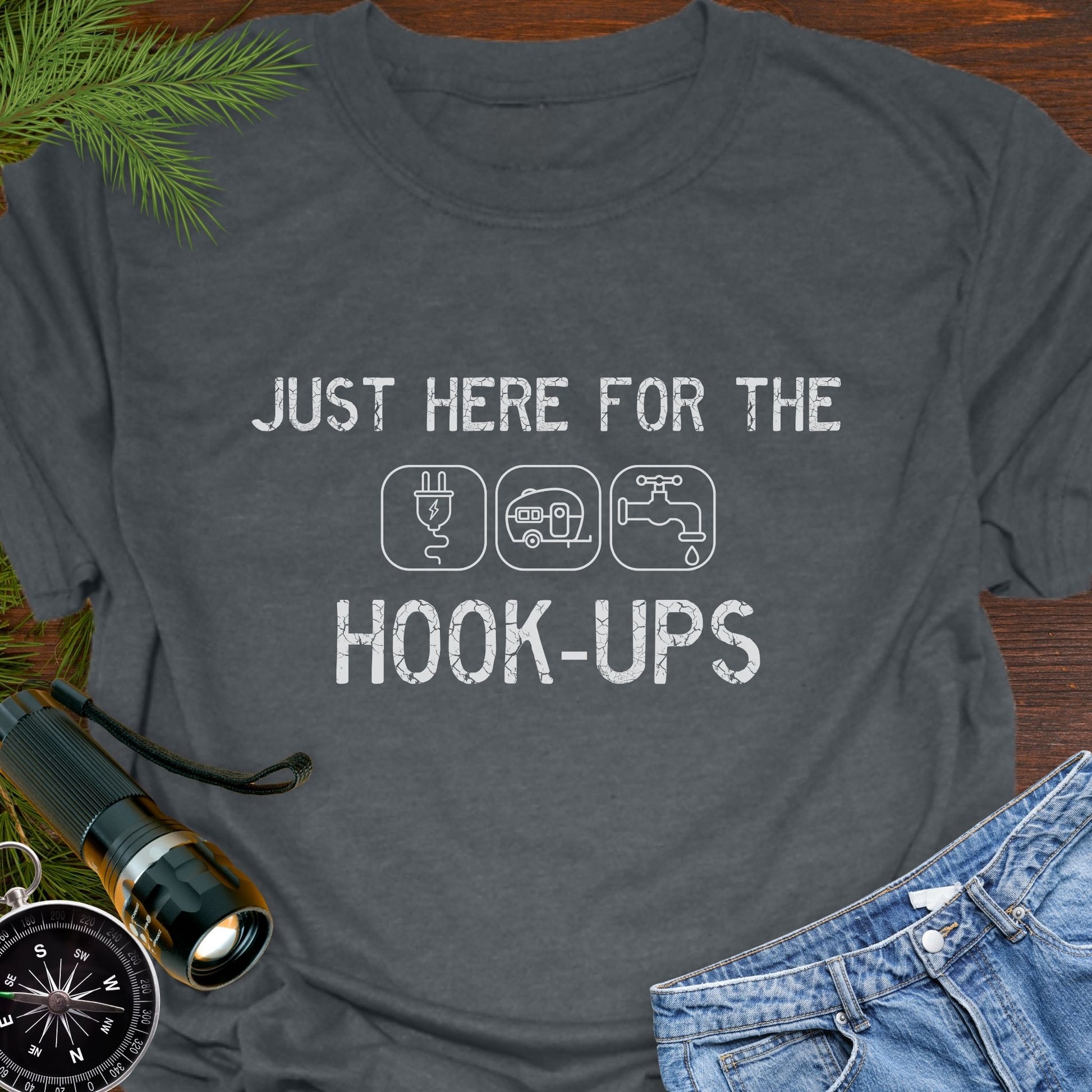 Dark Heather funny camping t-shirt with ‘Here for the Hook-ups’ text and RV utility icons.