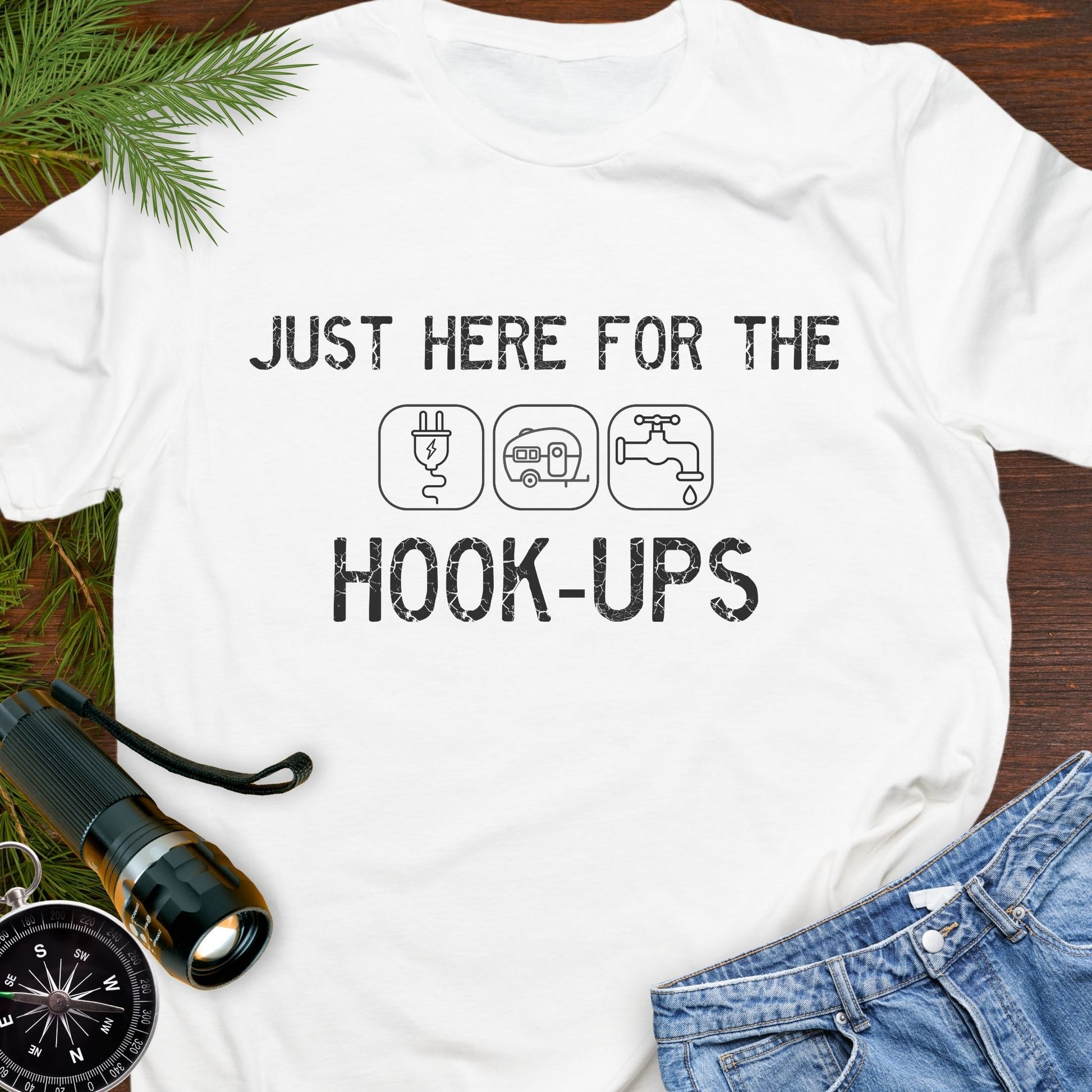 White funny camping t-shirt with ‘Here for the Hook-ups’ text and RV utility icons.