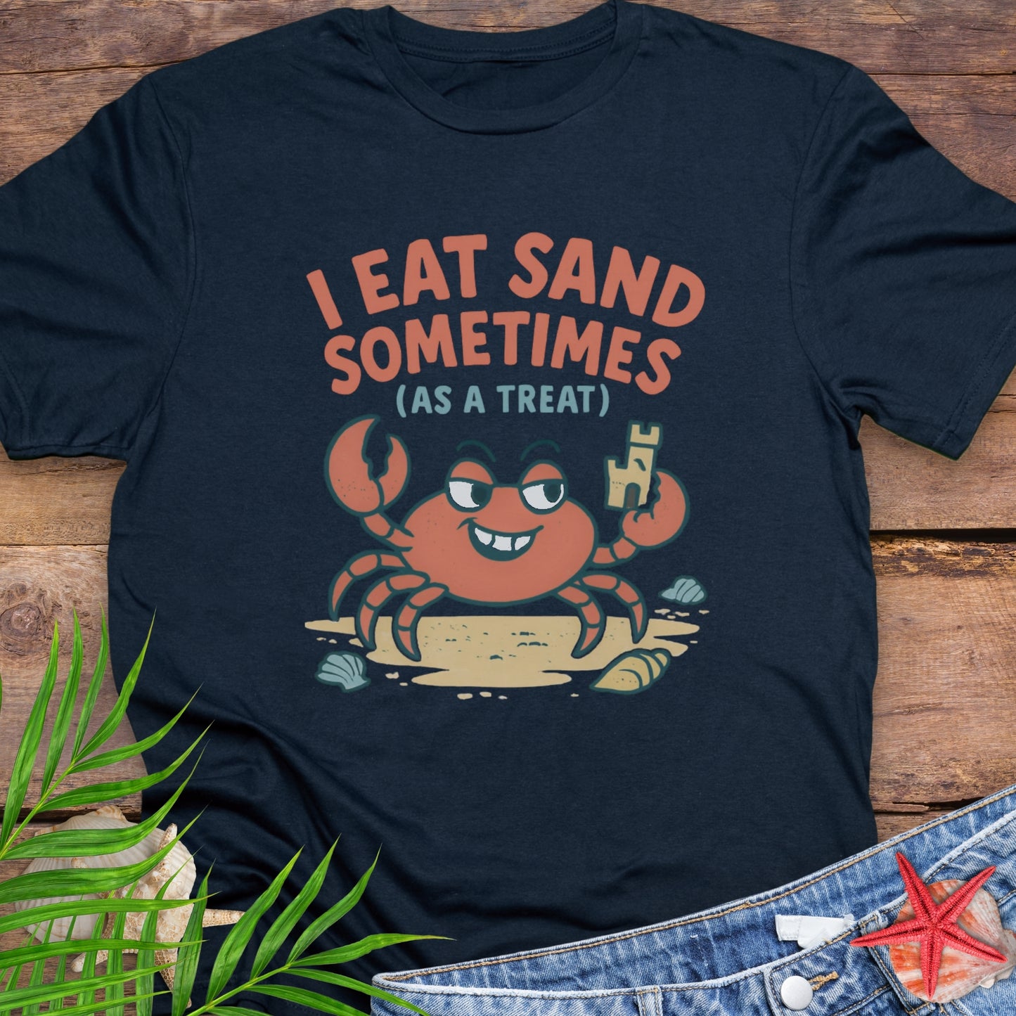 Navy blue I Eat Sand Sometimes as a Treat shirt featuring crab holding sandcastle.