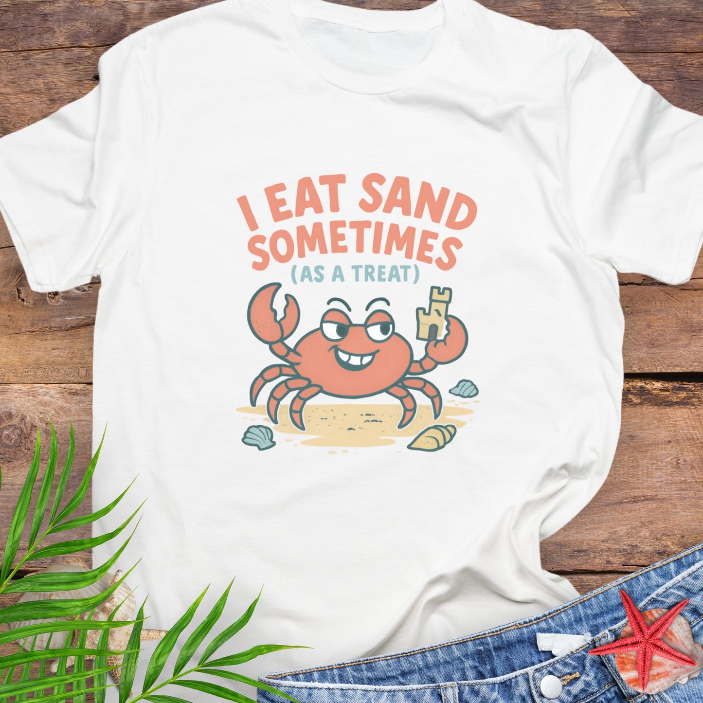 White I Eat Sand Sometimes as a Treat shirt featuring crab holding sandcastle.