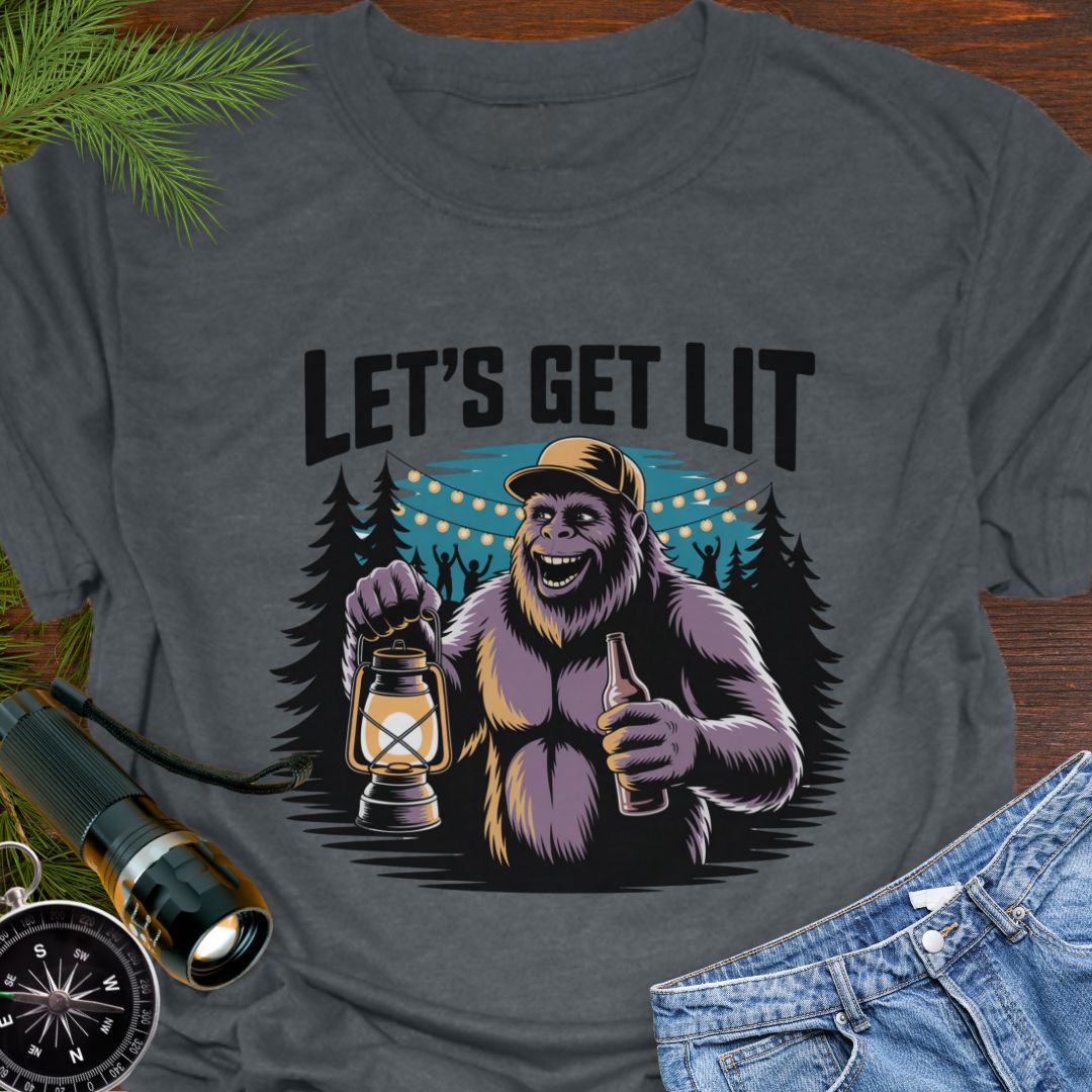 Dark Heather "Let's Get Lit" Sasquatch T-Shirt featuring a sasquatch wearing a baseball hat holding a camping lantern and a beer in a party scene in the woods.