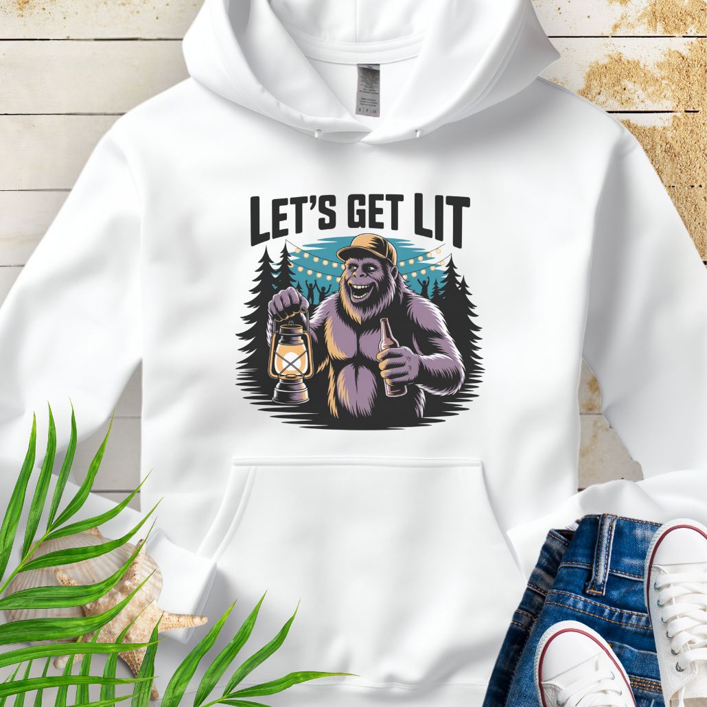 White funny Sasquatch camping unisex hoodie with relaxed outdoor party vibe that says Let's Get Lit featuring a sasquatch wearing a ball cap holding a camping lantern and a bottle of beer with the forest in a forest camp scene.