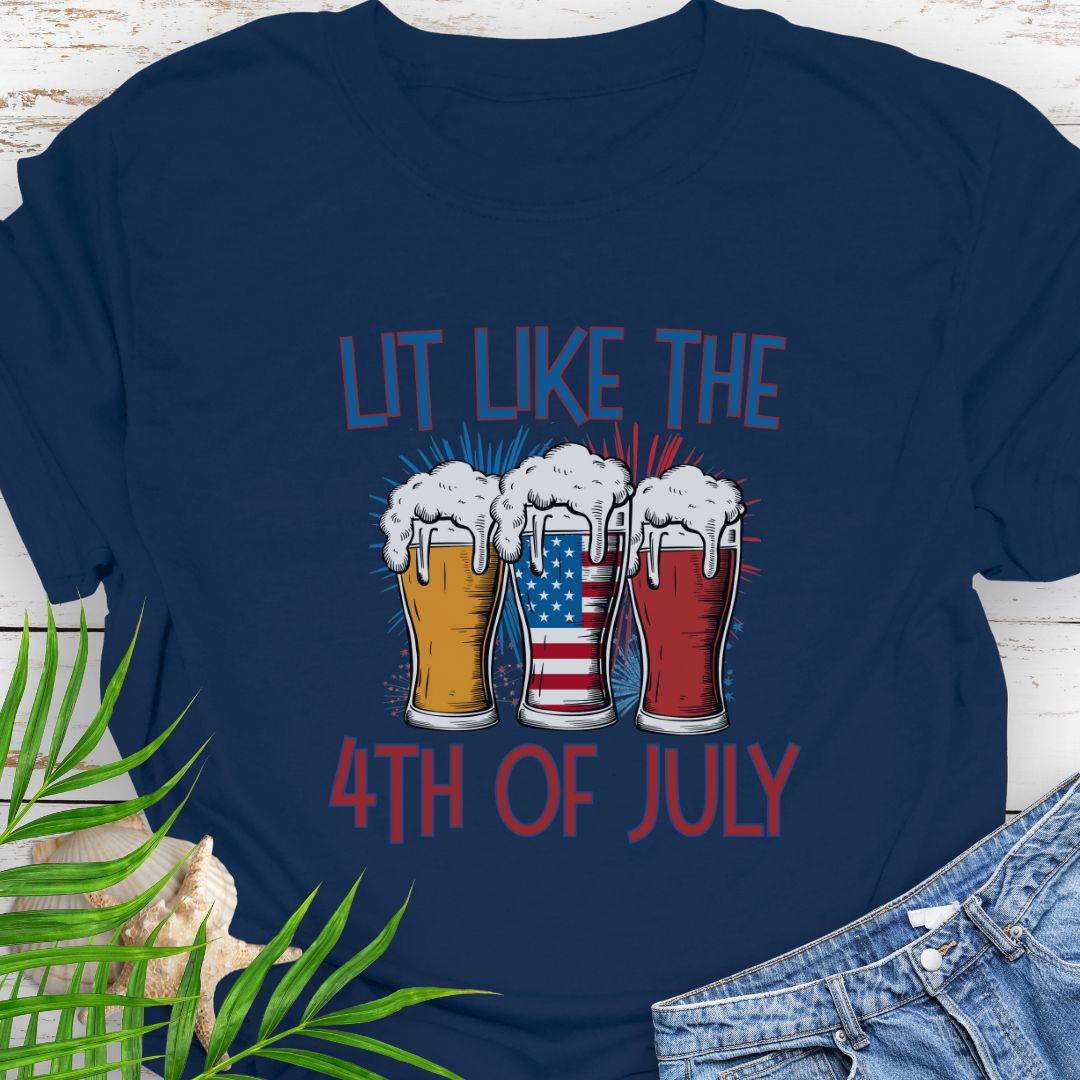 Navy T-shirt graphic showing three pint glasses of beer with one filled by the American flag and the phrase "Lit Like the 4th of July" in bold lettering.