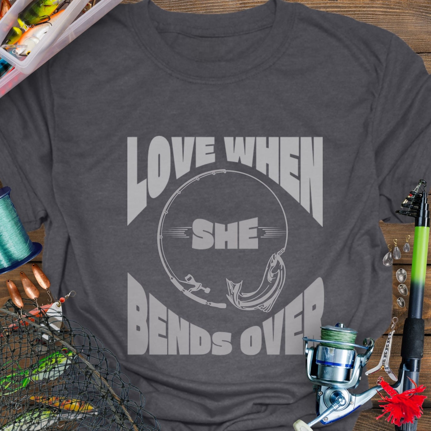 Dark Heather T-shirt with a fishing pole bending over and the phrase “Love When She Bends Over” – humorous fishing design for anglers.