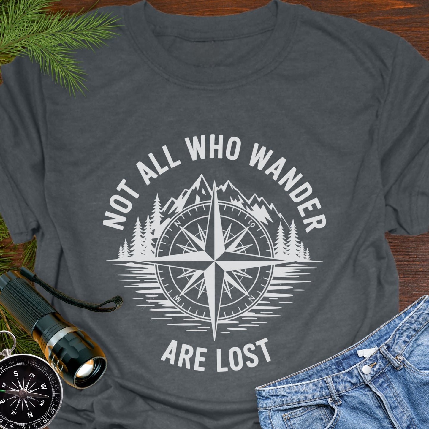 Dark Heather T-shirt with a mountain range and lake with a compass overlay that says Not All Who Wander are Lost.