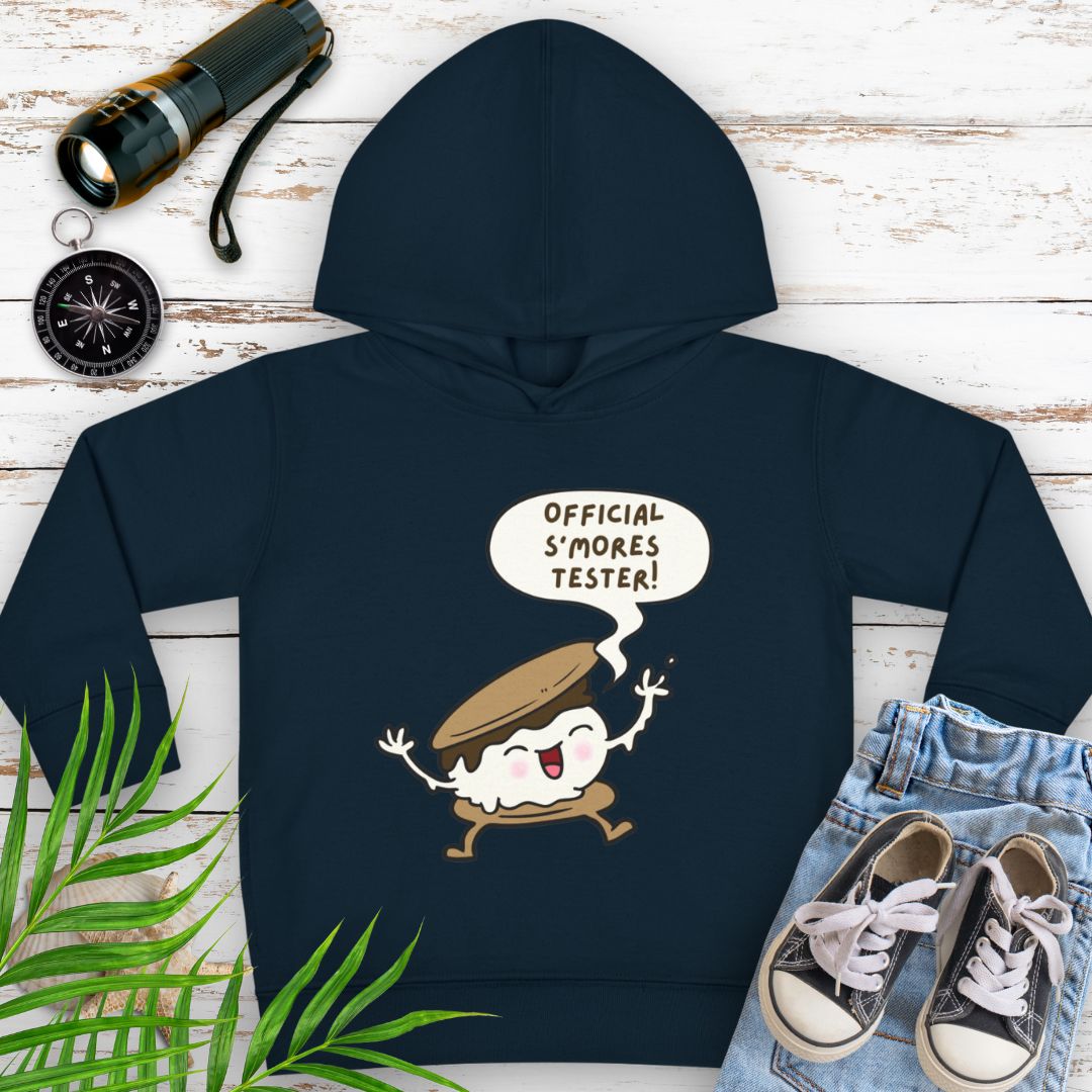 Navy cozy toddler hoodie with “Official S’mores Tester” speech bubble and a cartoon s'more – cute outdoor-themed sweatshirt for little campers.