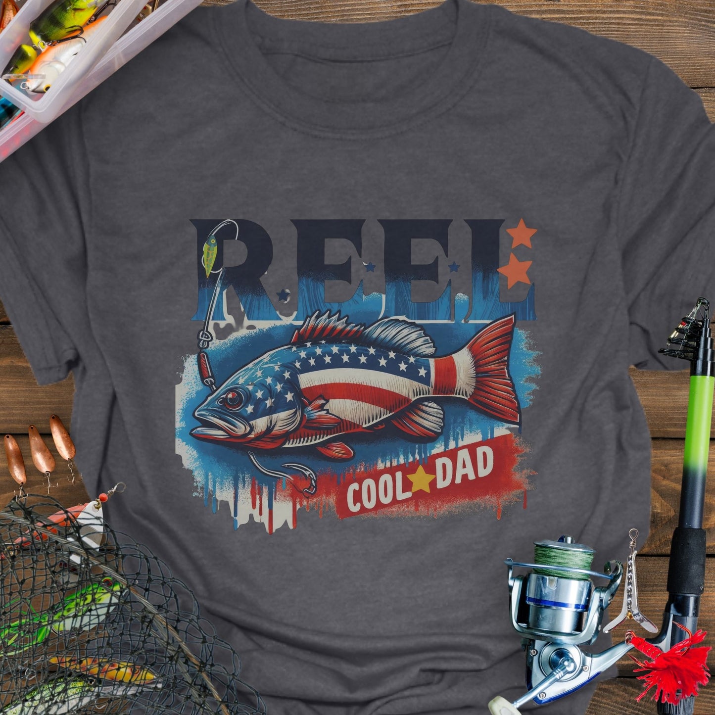 Dark Heather patriotic fishing T-shirt with red, white, and blue design and the phrase “Reel Cool Dad”.