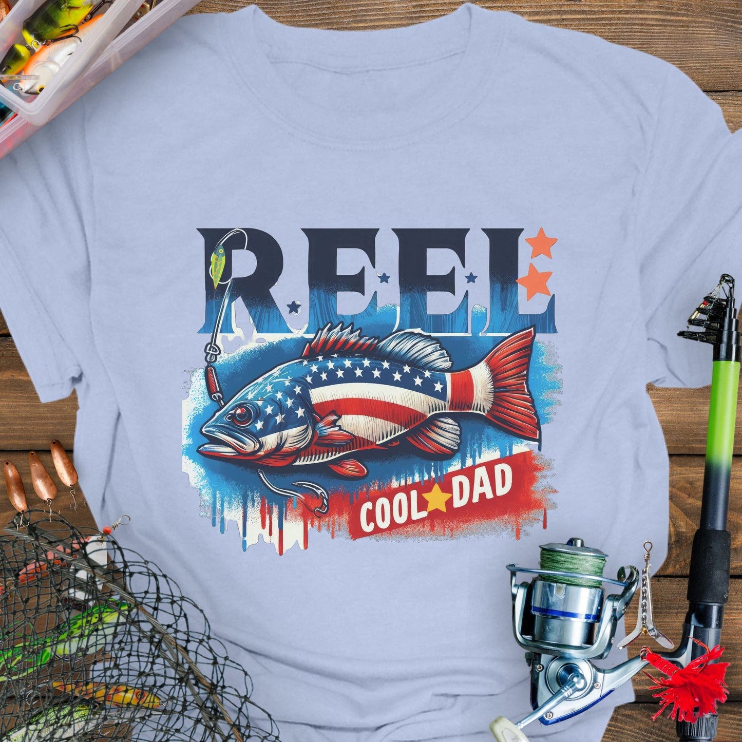 Light Blue patriotic fishing T-shirt with red, white, and blue design and the phrase “Reel Cool Dad”.