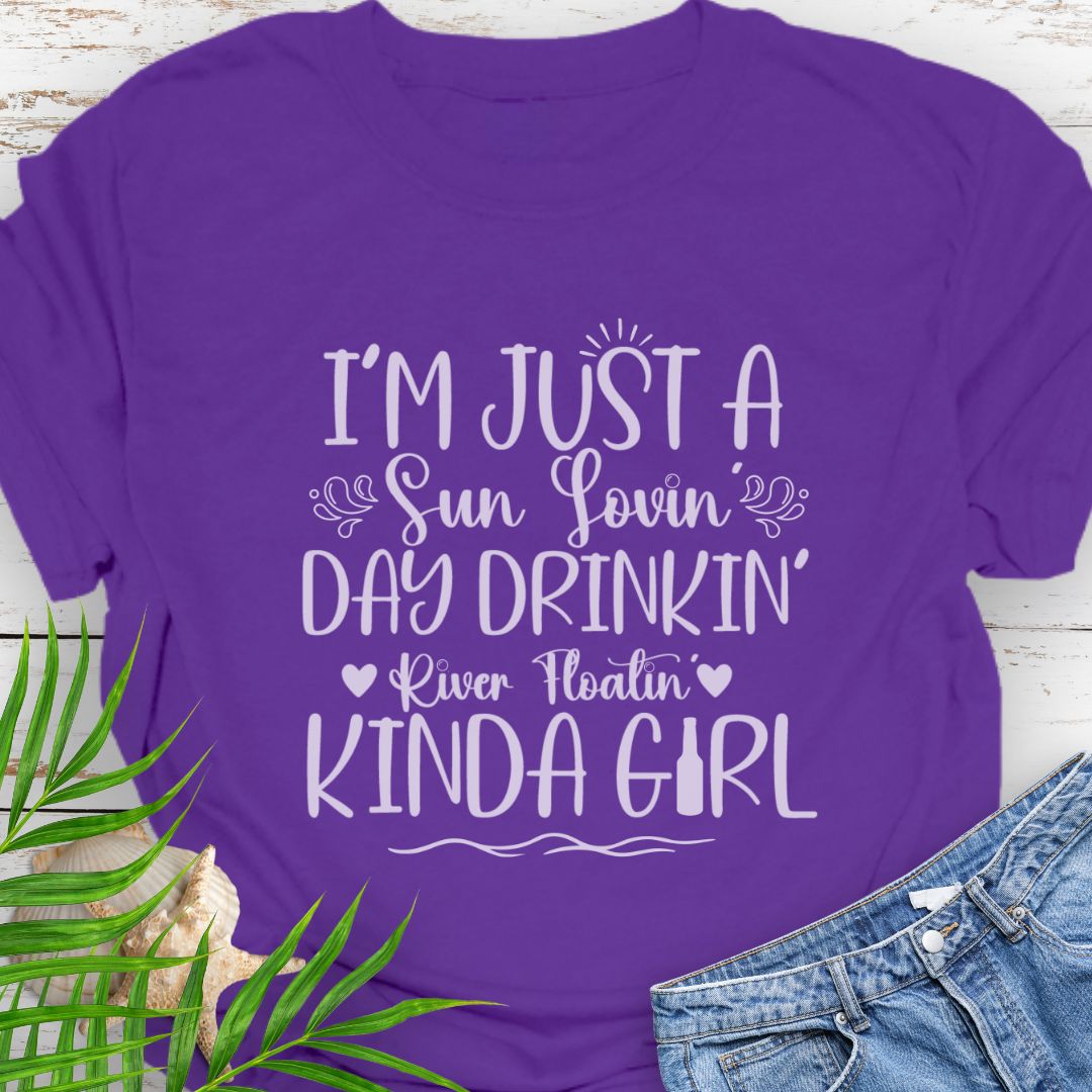 Purple Unisex t-shirt with the phrase "Sun-loving, Day-drinking, River-floating Kind of Girl" printed on the front with embellishments, featuring a relaxed fit and soft cotton fabric.