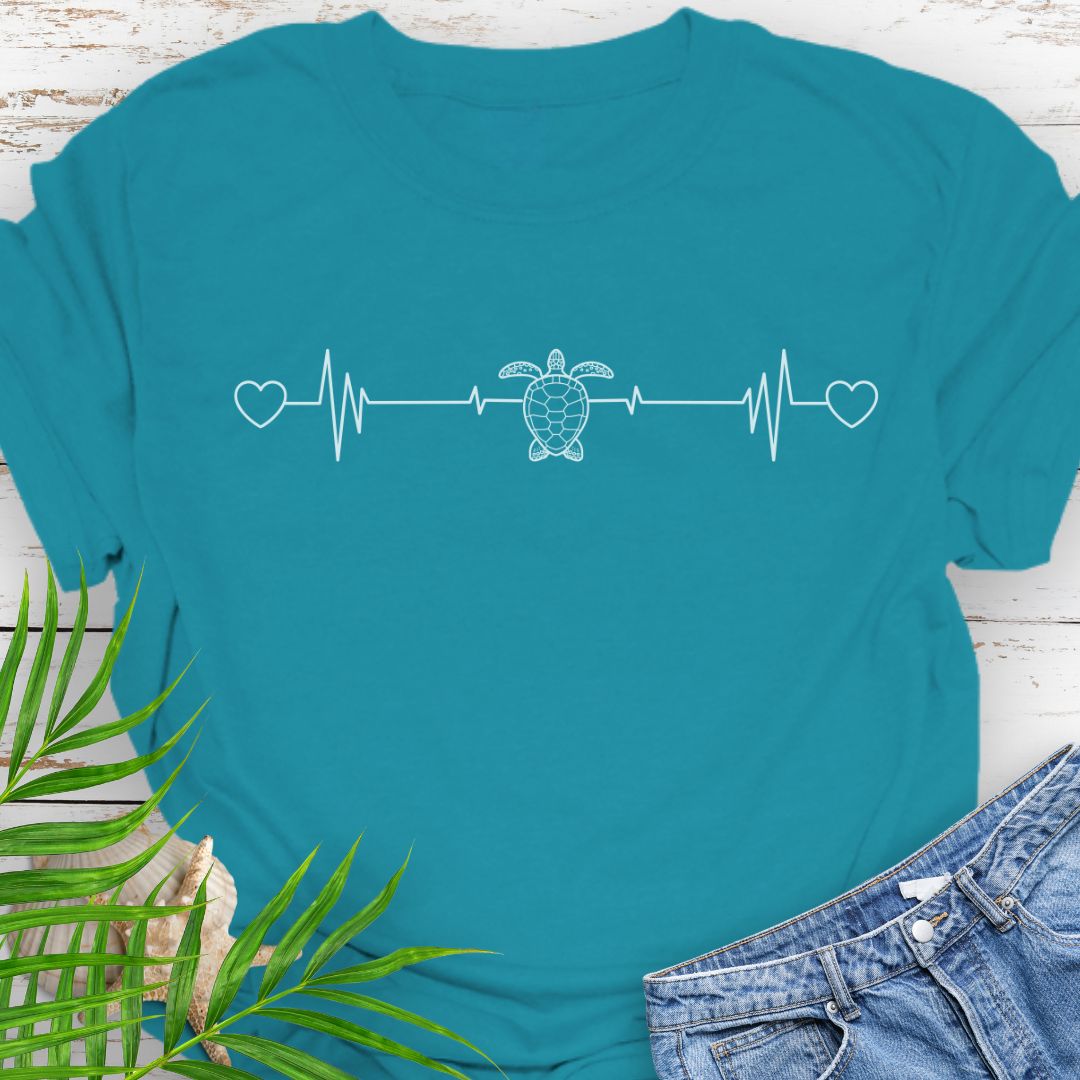 Tropical Blue T-shirt with ocean heartbeat design with sea turtle in center symbolizing love for sea turtles.