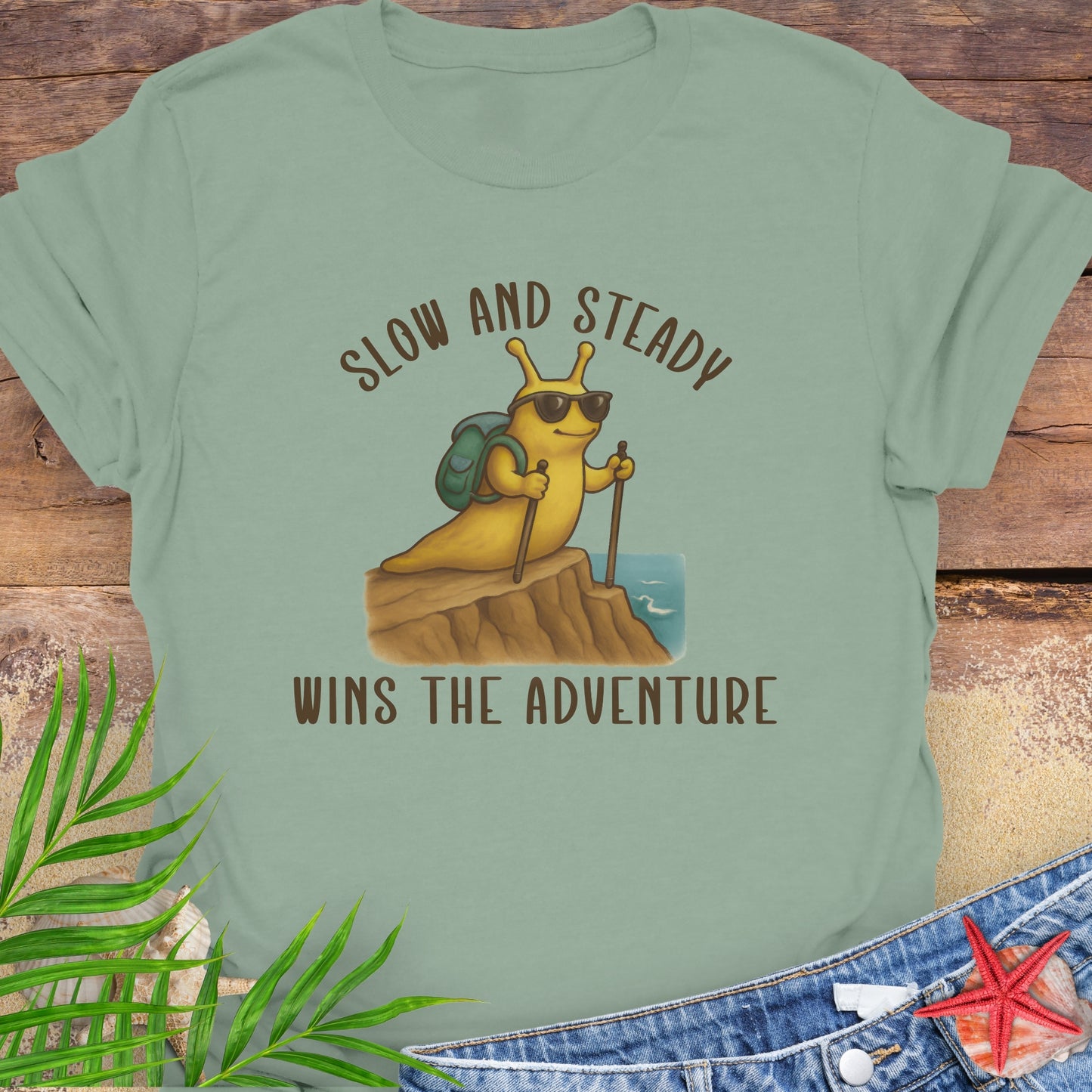 Green t-shirt with a cartoon snail and text 'Slow and Steady Wins the Adventure'.