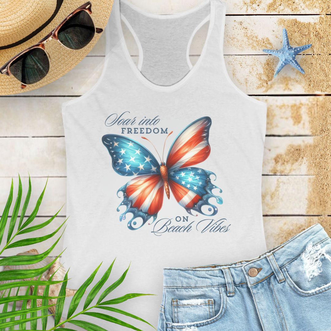 White patriotic women’s tank top with a American flag butterfly design and “Soaring into Freedom” slogan, featuring a scooped neckline and tear-away label.