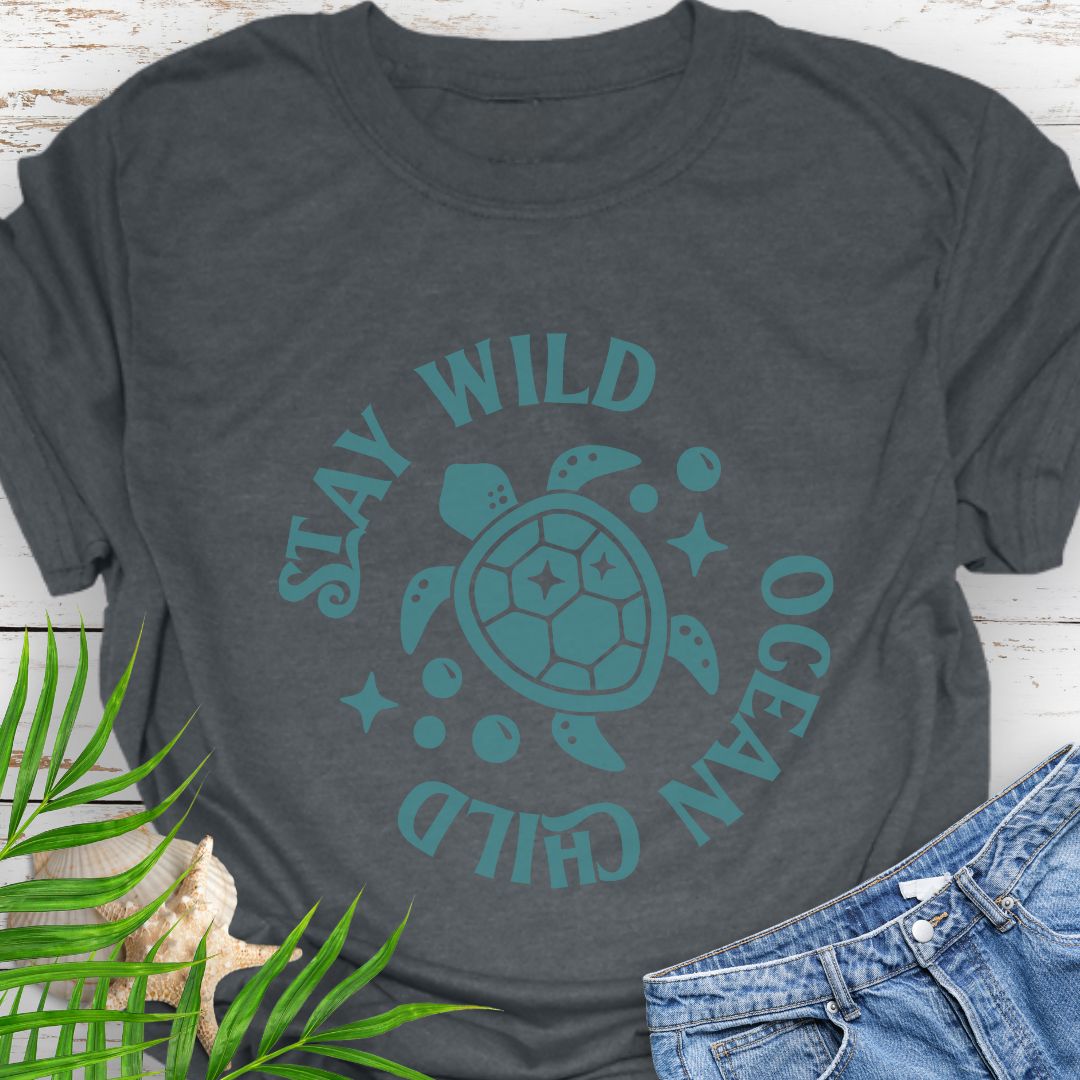 Dark Heather Stay Wild Ocean Child Sea Turtle T-Shirt featuring a sea turtle with phrase around the turtle - a beachy, free-spirited vibe for sea lovers.