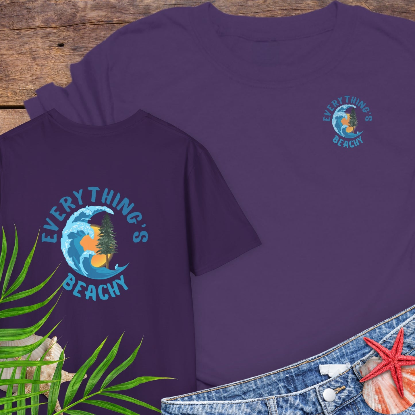 Purple t-shirt with Everything’s Beachy logo with wave, sun, and redwood graphic.