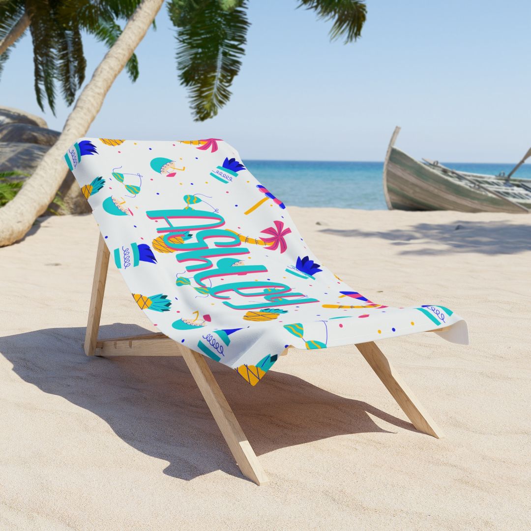 Colorful beach towel with pineapples, umbrellas, bikini, plants, palm trees, and personalized name.
