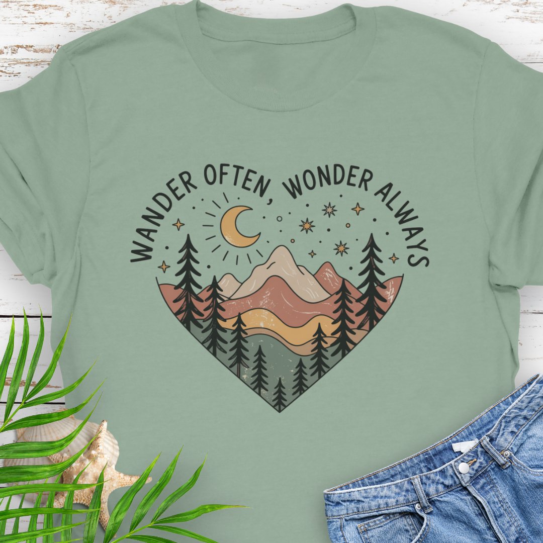 Sage green Unisex t-shirt with mountain and trees in a heart shape and the phrase "Wander Often, Wonder Always".
