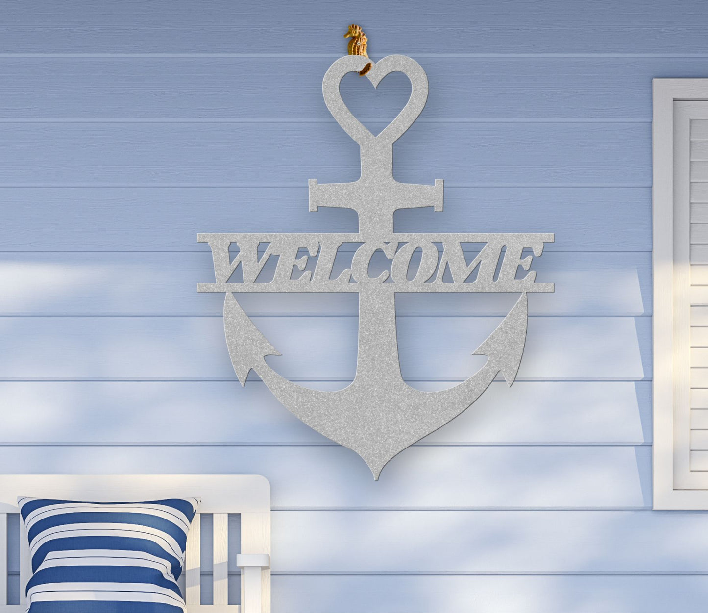 Silver metal wall art shaped like an anchor with a heart at the top and the word “Welcome” cut out in the center; made of powder-coated steel.