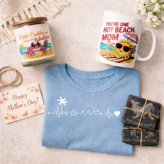 Beachy Mother’s Day gift set with coastal candle, funny mug, blue beach-themed t-shirt, and ocean-inspired coasters.