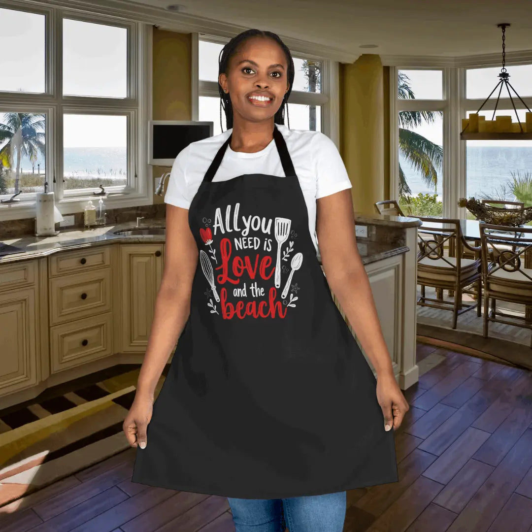Man standing at bbq grill with an apron with a picture of a sunset and a graphic of palm trees with the saying BBQS, Beaches and Bliss.