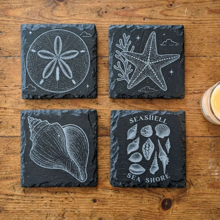 Set of 4 Black Slate Coasters with Seashell designs.