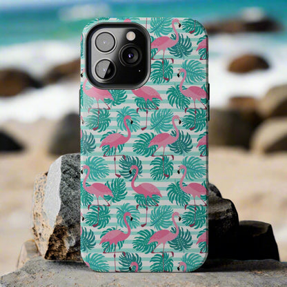 Phone case with flamingo and leaf pattern laying against rocks at the beach.