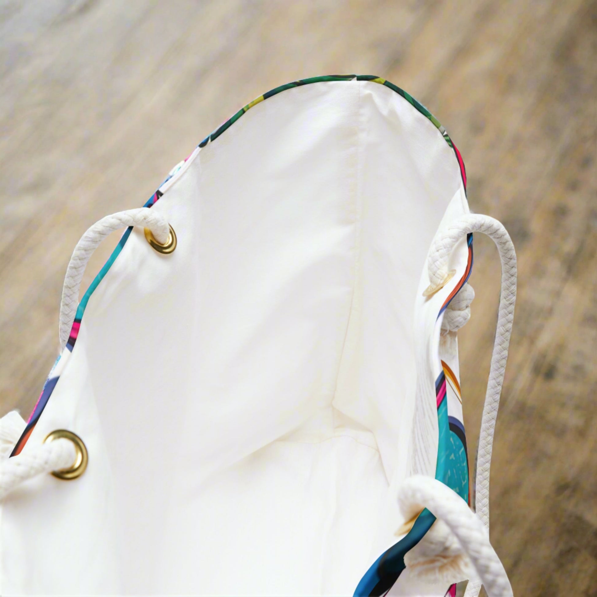 Showing the inside of a weekender tote with a white inside and rope handles with metal grommets 