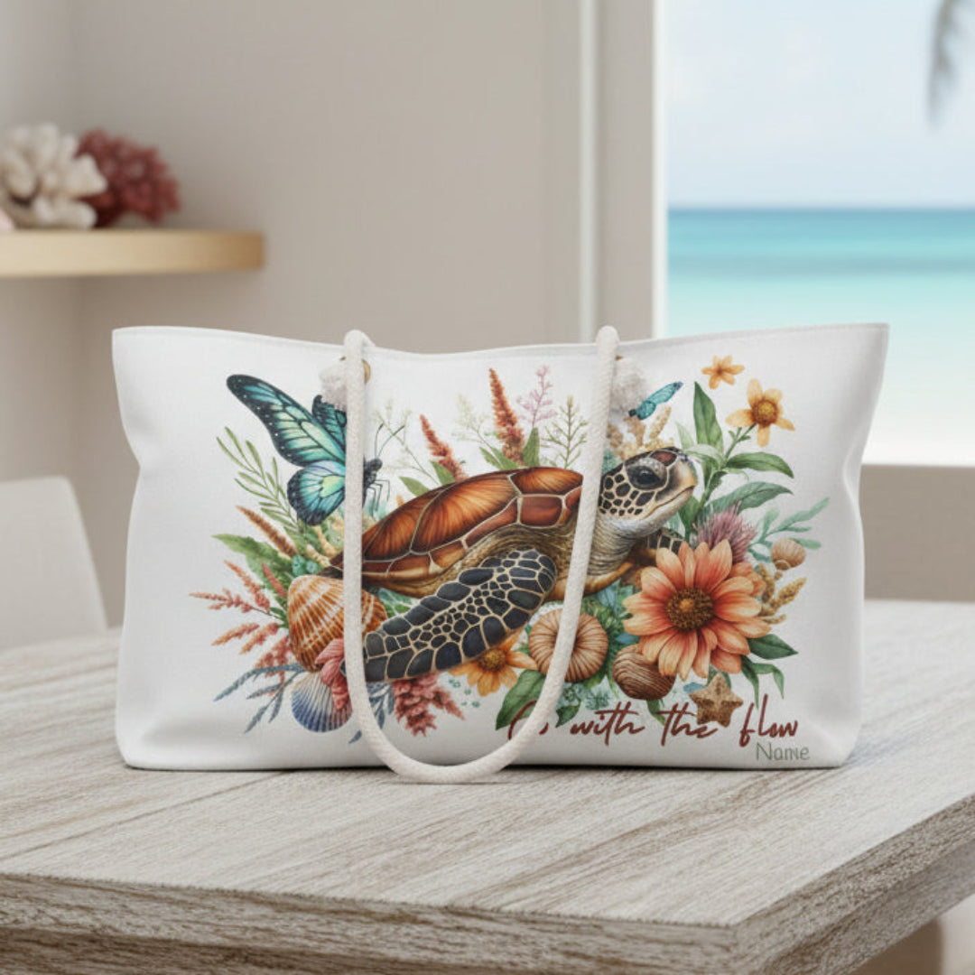 Tote bag with a turtle, butterfly, and floral design on a white background