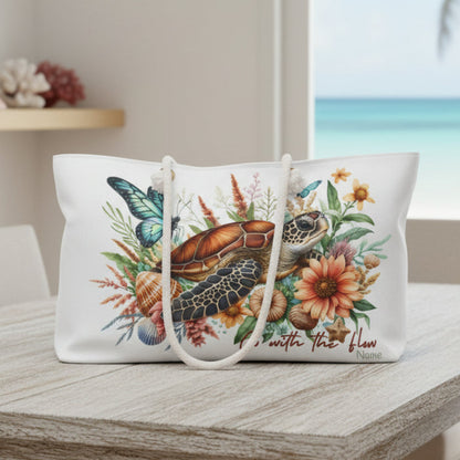 Tote bag with a turtle, butterfly, and floral design on a white background