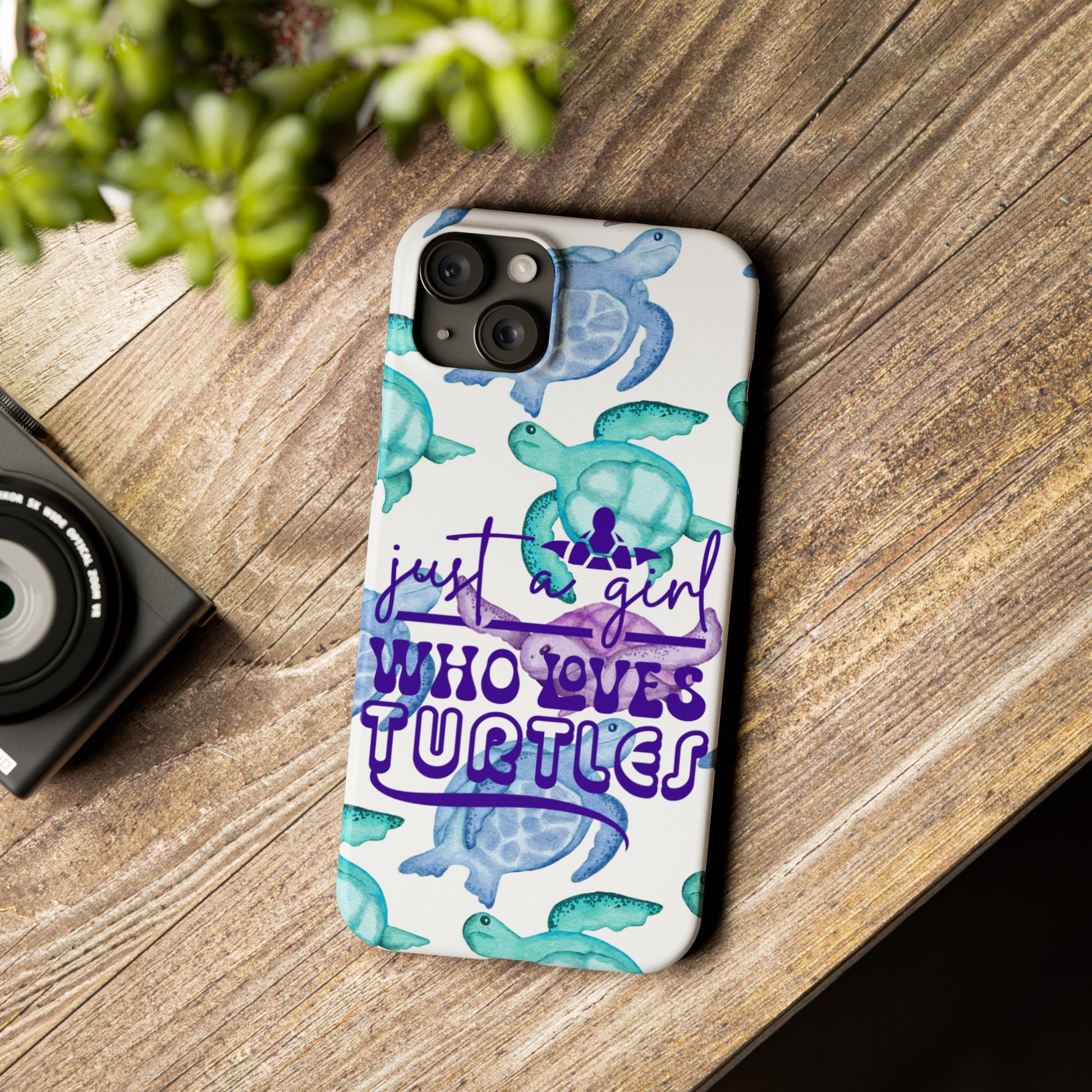 Iphone case with turquoise, blue and purple sea turtles that says  Just a Girl Who Loves Sea turtles laying on wood table