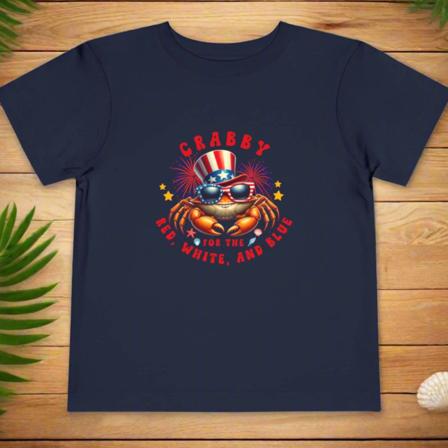 Navy blue t-shirt with a crab graphic and text on a wooden surface