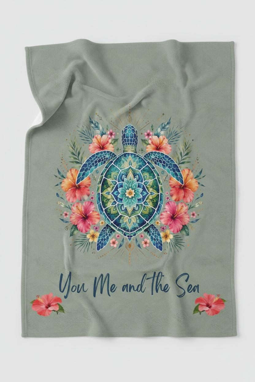 An ultra-soft plush throw blanket featuring a vibrant mandala sea turtle surrounded by tropical hibiscus flowers with the phrase "You, Me and the Sea" on a sage-green background.