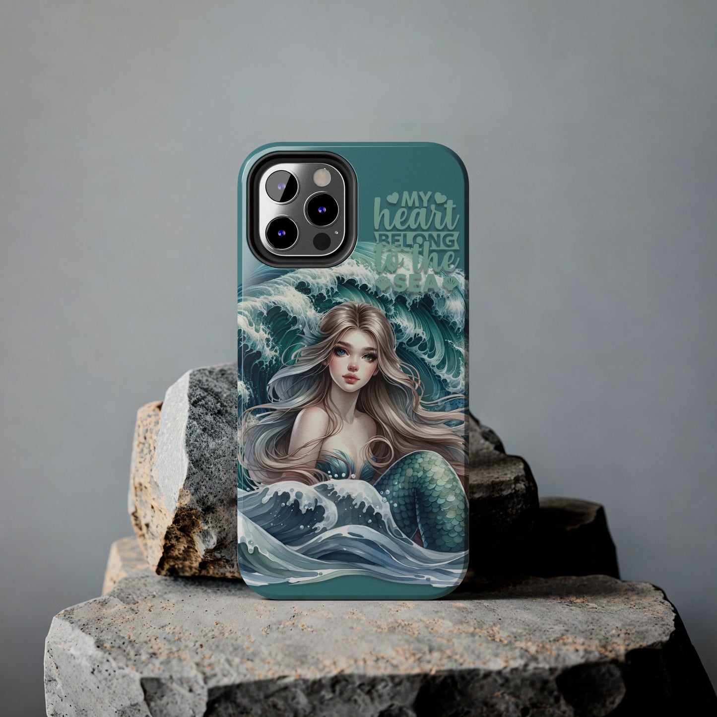 Phone Case with Flowy mermaid with ocean wave behind and text My Heart Belongs to the Sea against rock