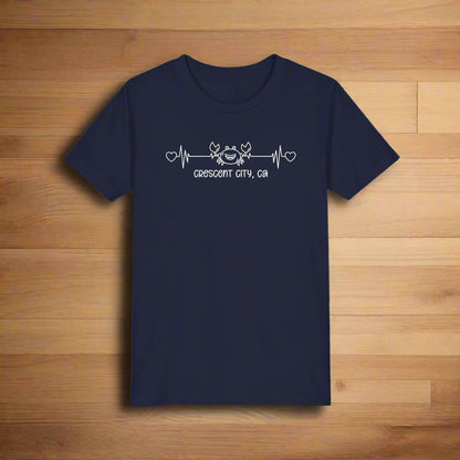 Navy Child t-shirt with a smiley crab on a heartbeat line with hearts at both ends and “Crescent City, CA” underneath the design.