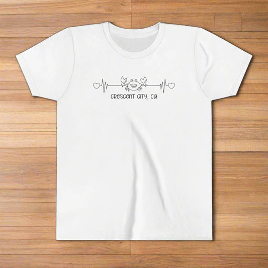 White Youth t-shirt with a smiley crab on a heartbeat line with hearts at both ends and “Crescent City, CA” underneath the design.