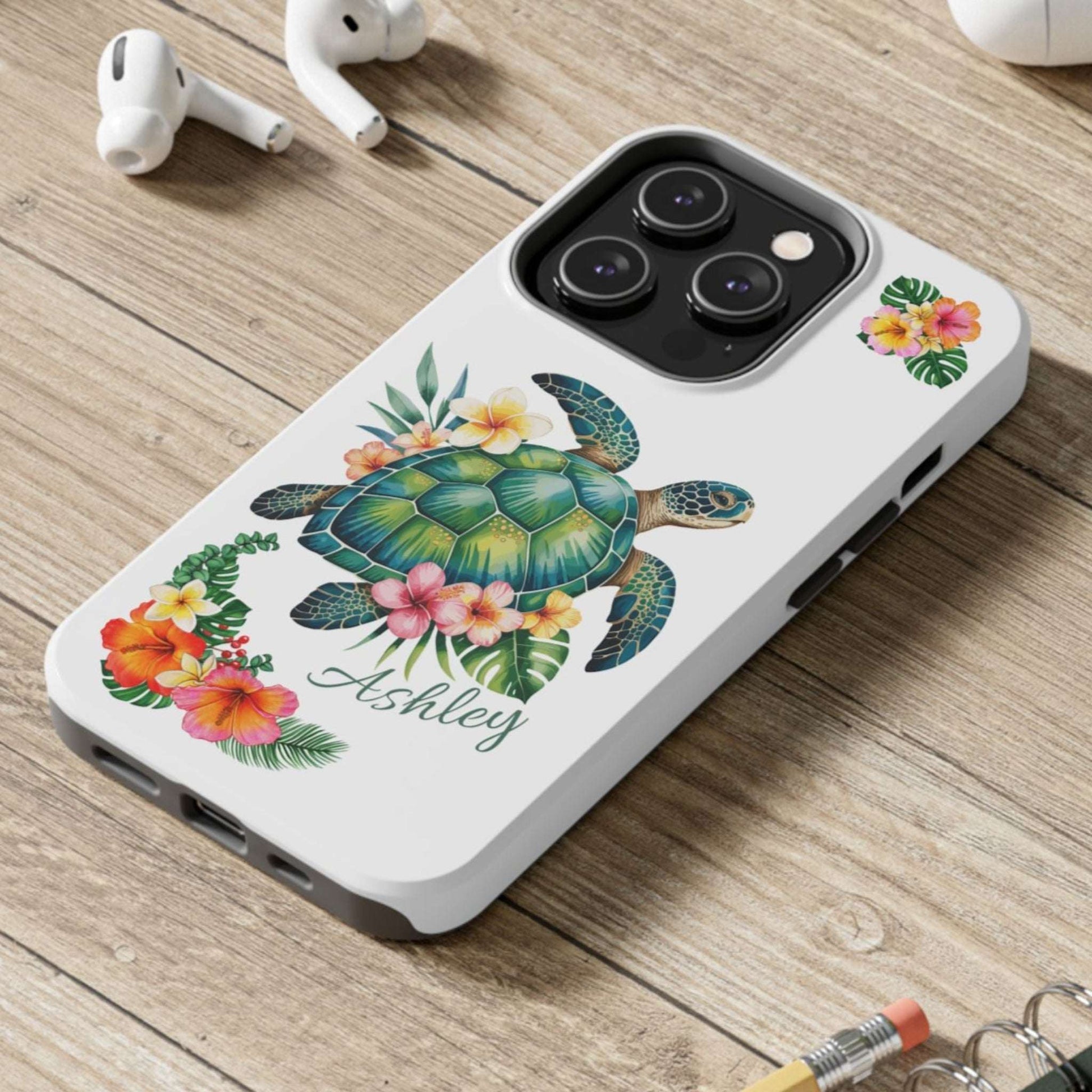 iPhone 14 case with a white background and a sea turtle with hibiscus flowers, with more hibiscus flowers around the sides.