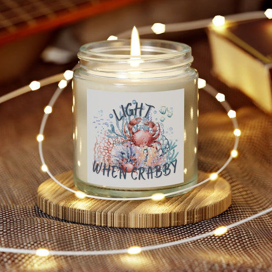 Candle in a jar with a decorative label on a wooden coaster, surrounded by string lights and a guitar in the background.