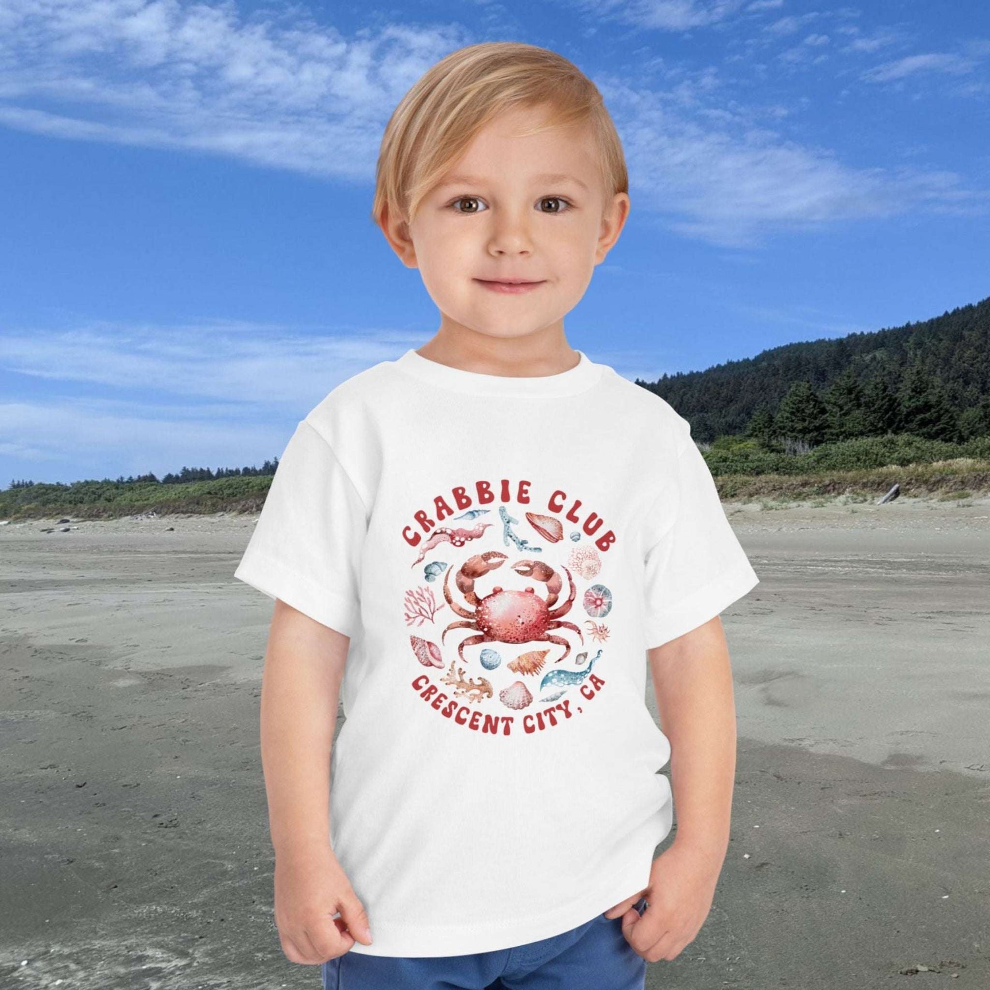 White Toddler t-shirt with the phrase “Crabbie Club Crescent City, CA” and a playful cartoon crab graphic.