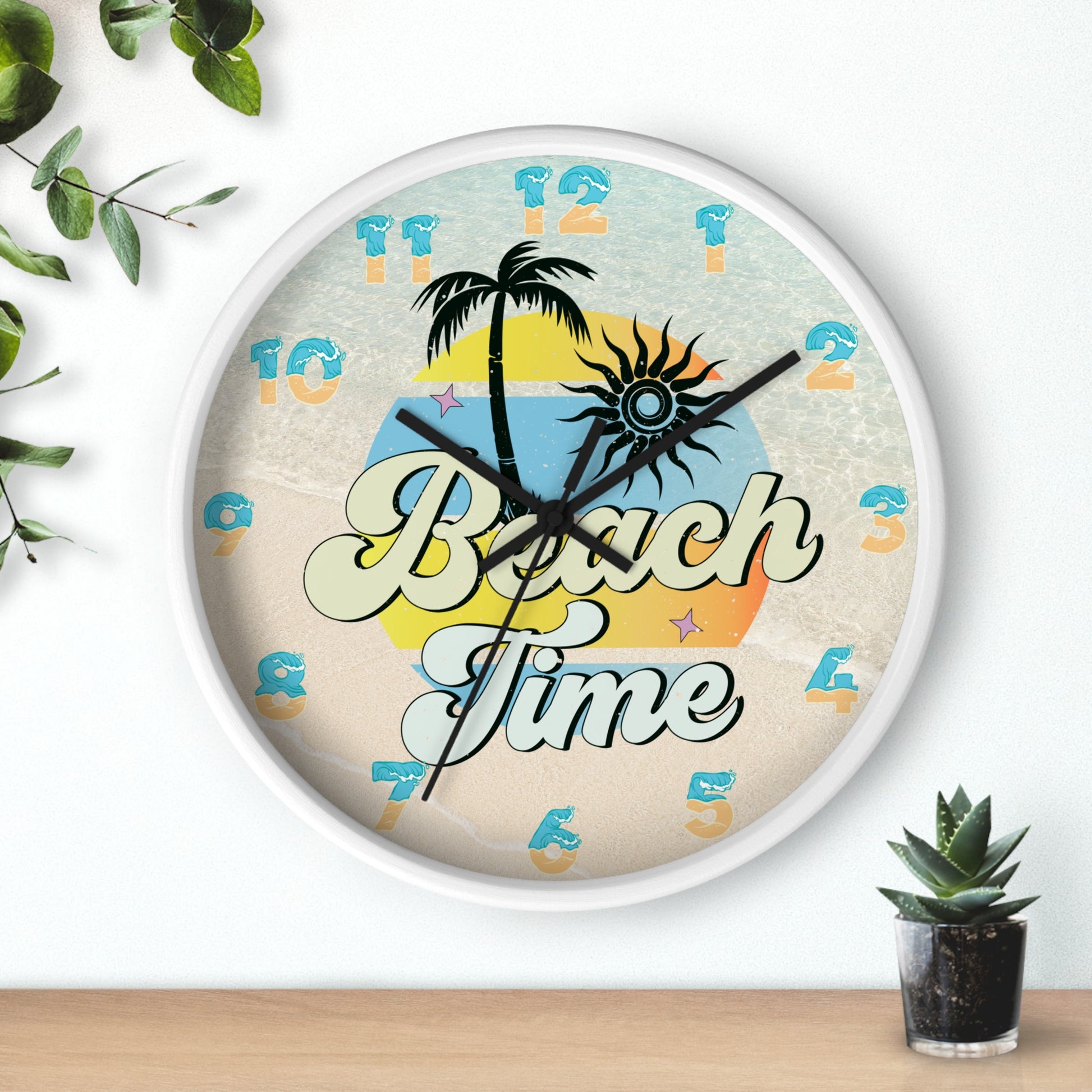 A circle wall clock with a white frame and black handles with an image of palm trees and sunset with a background of ocean water and sand that says Beach Time.