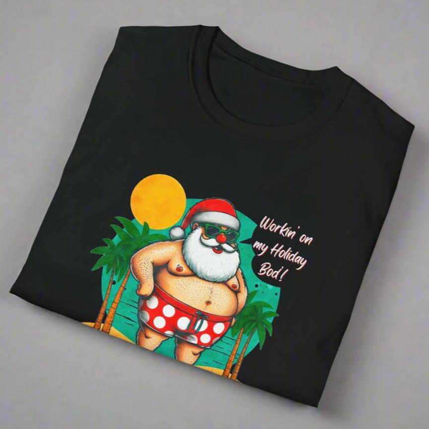 Close up of T-shirt with Santa with swim shorts on the beach with text Workin' on my Holiday Bod'!