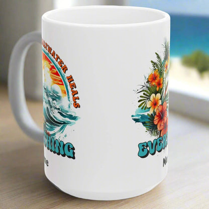 Side view of 10 oz. White ceramic mug with an ocean scene surrounded by tropical flowers with the text Saltwater Heals Everything and the word Name underneath where it can be personalized.