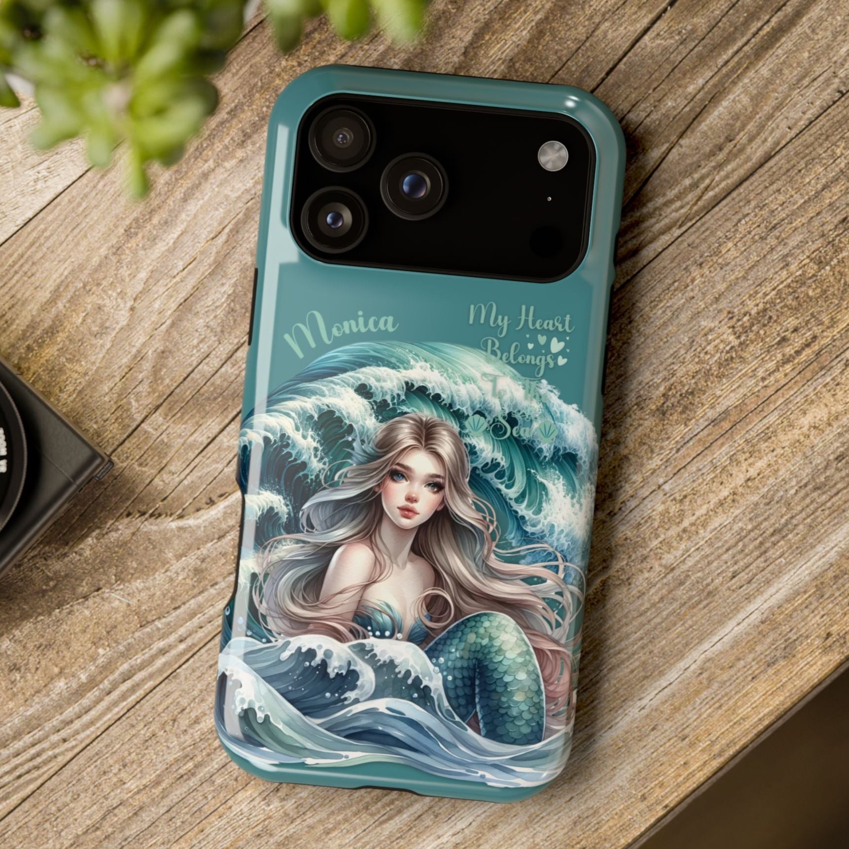Phone case with mermaid design on a wooden surface