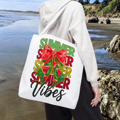 White 18" x 18" tote bag with the word "Summer" repeated in green, red, and yellow, featuring a coquette-style bow, watermelon illustrations, and the word "Vibes" underneath.