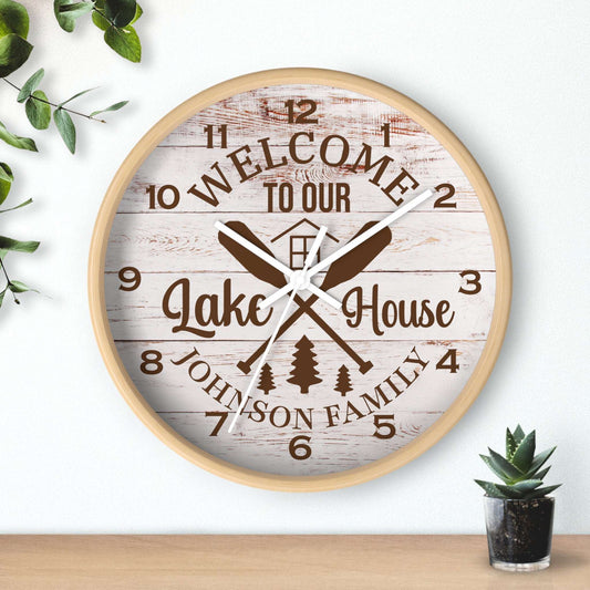 Wall clock with 'Welcome to our Lake House' text and decorative elements on a light background.